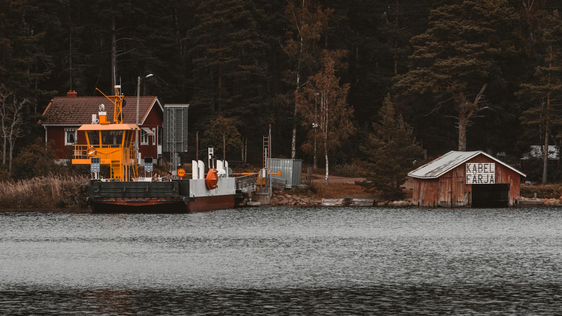 Drewniana przystań przy promie wśród lasów wysp Alandzkich latem