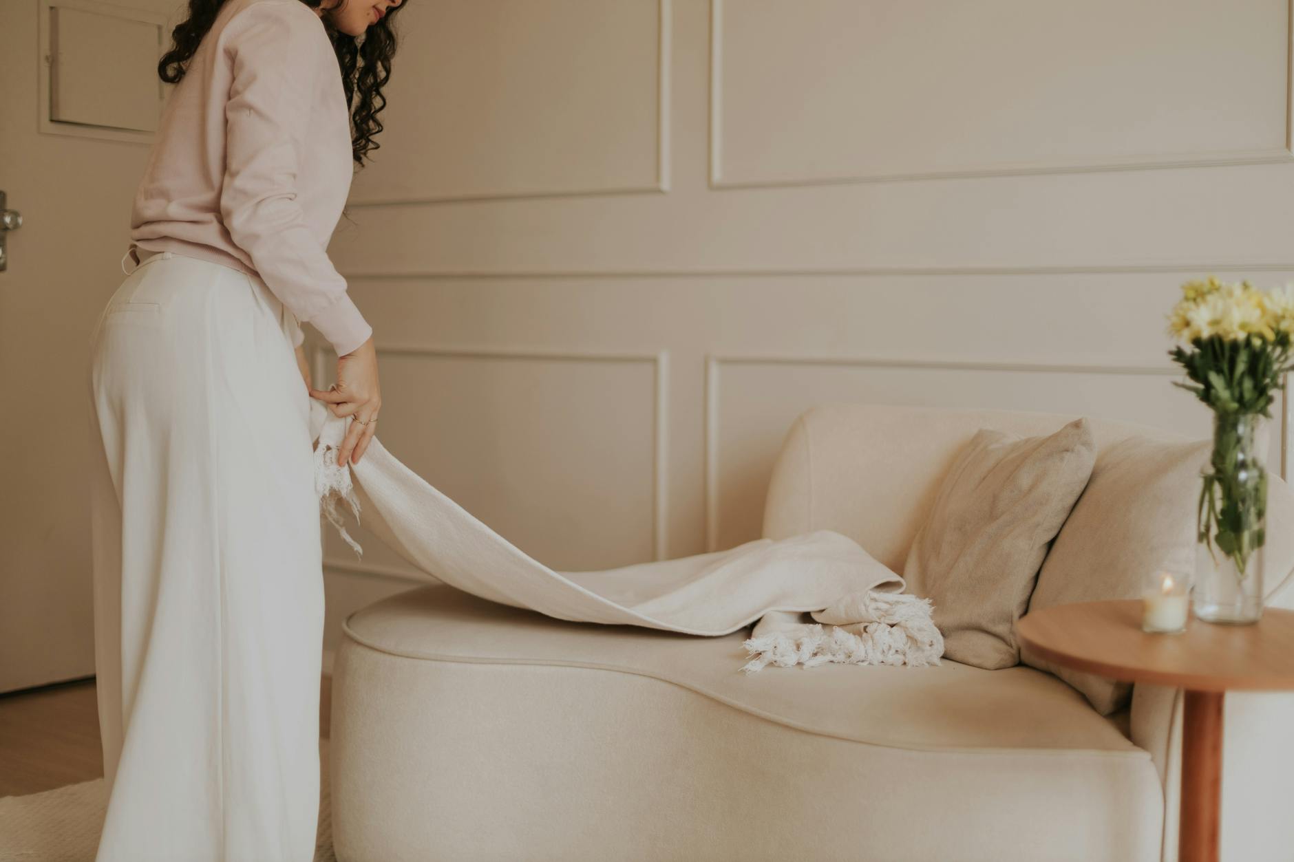 Jasny minimalistyczny salon z beżową sofą i przytulnymi dodatkami