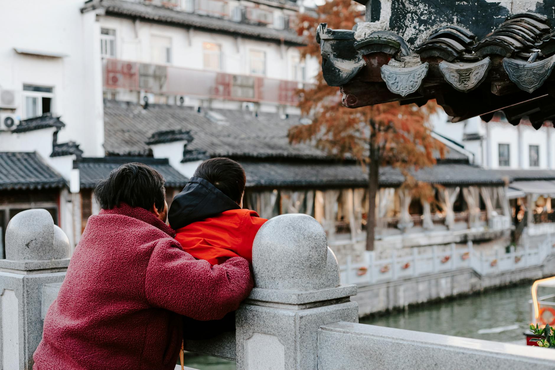 Rodzina spaceruje przy tradycyjnej zabudowie w jesiennym Nankinie w Chinach