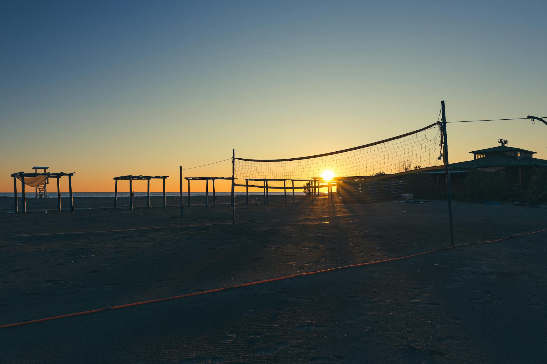 Boisko do siatkówki plażowej nad jeziorem o zachodzie słońca