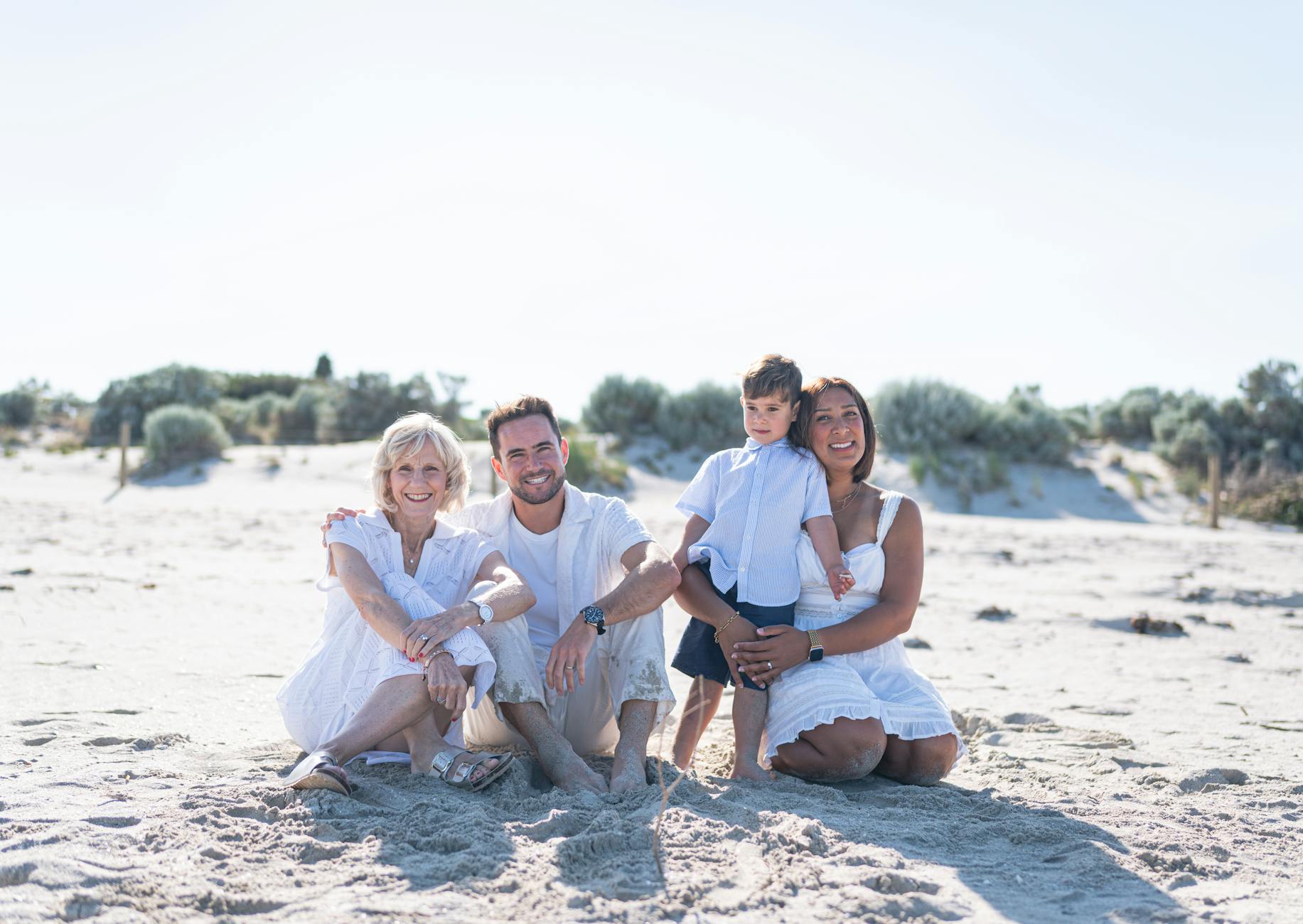 Rodzina z dziećmi siedzi na piaszczystej plaży nad Balatonem