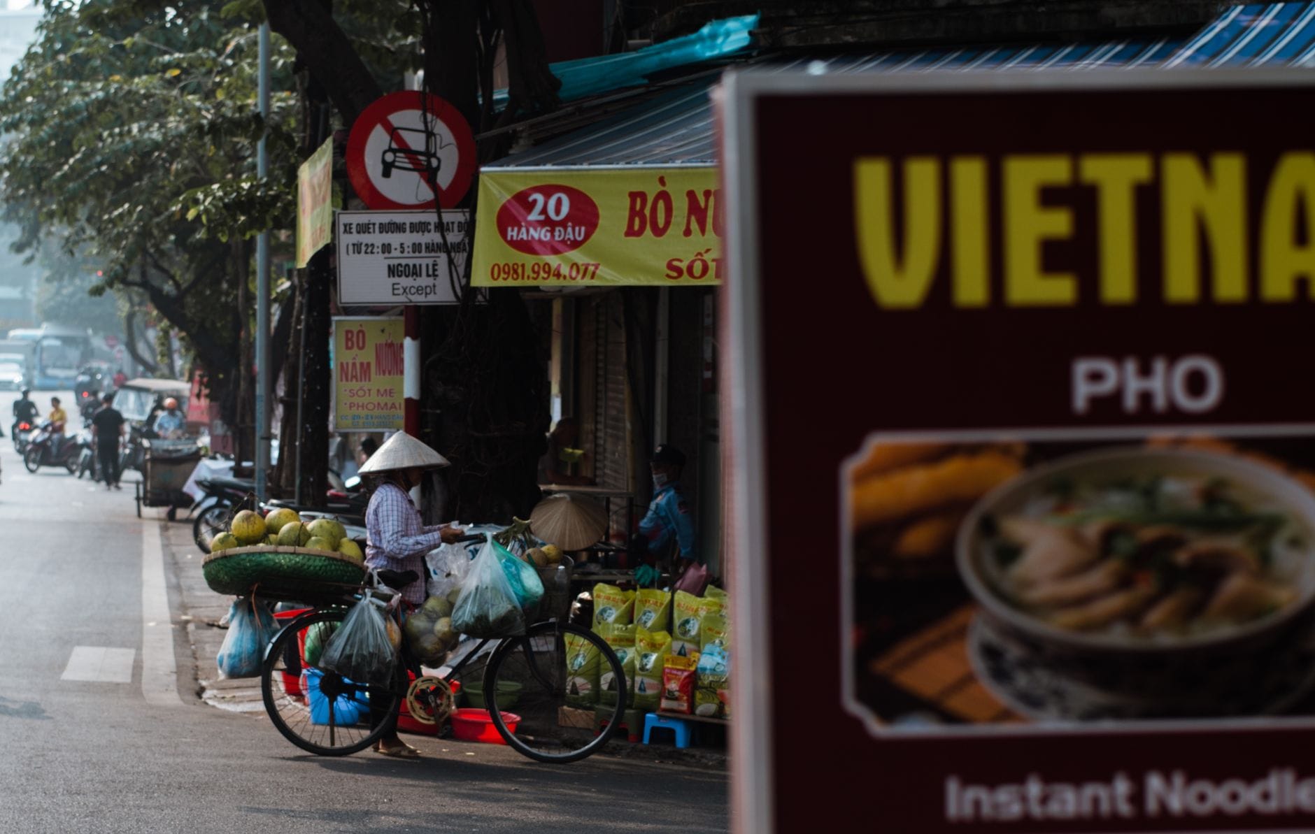 Hanoi w 48 godzin: plan zwiedzania i smaki ulicy Uliczny sprzedawca w Hanoi z rowerem pełnym warzyw i owoców